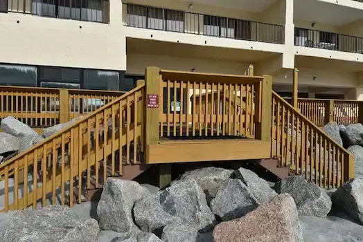 Timber landing and stairways outside Atalaya Towers overlooking the beach