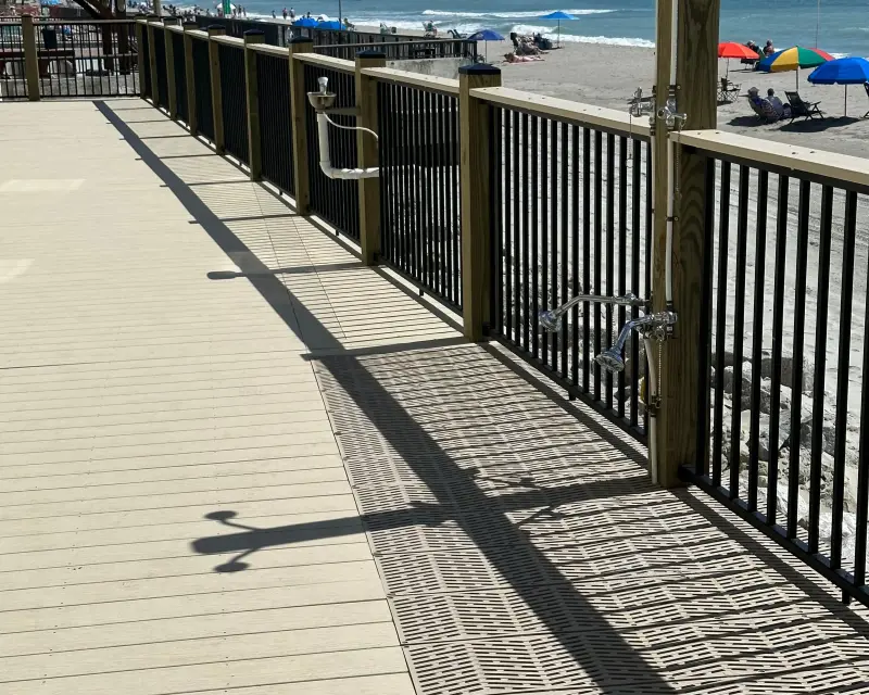 Oceanfront deck with timber posts, dark railings, and an outdoor shower at Horizon East