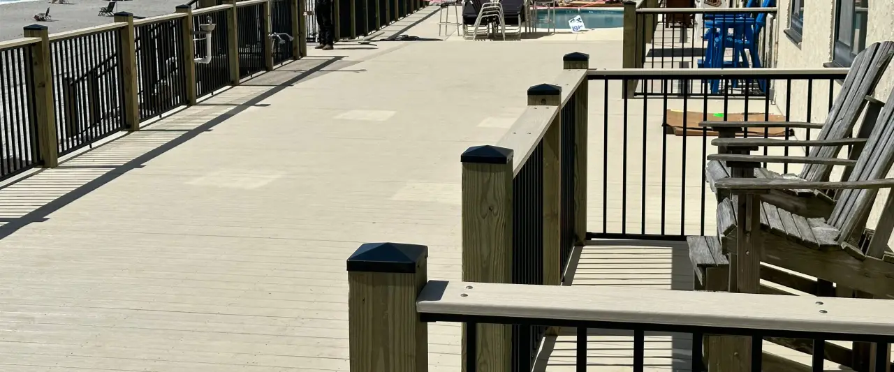 Coastal deck with black railings, timber posts, and seating at Horizon East