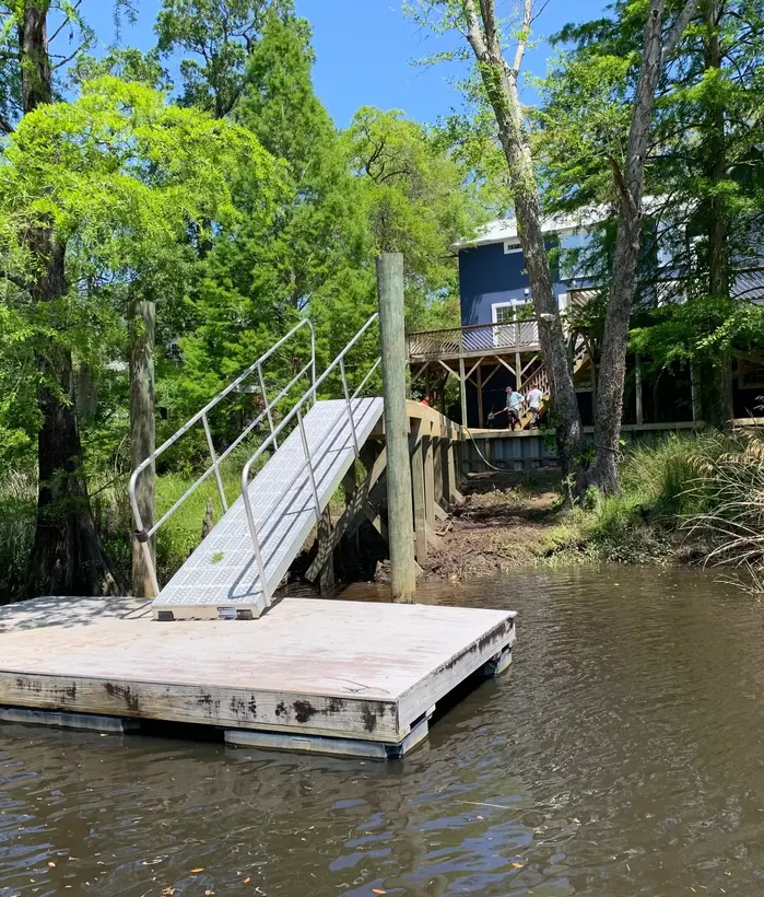 Floating dock and aluminum gangway connected to a wooded shoreline