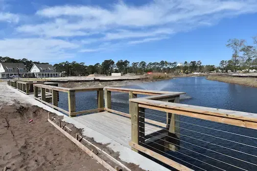 Timber-capped bulkhead and fishing deck with railings at Living Dunes at 82nd