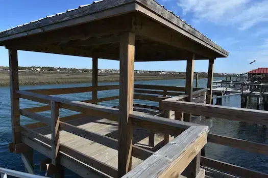 Corner view of the covered pierhead showing timber railings and the metal roof