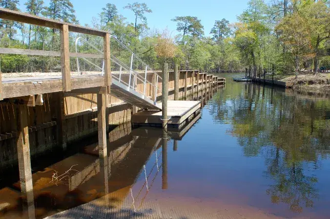Pawleys Island seawall and boat slip with timber railings, a metal gangway, and a floating platform beside the water