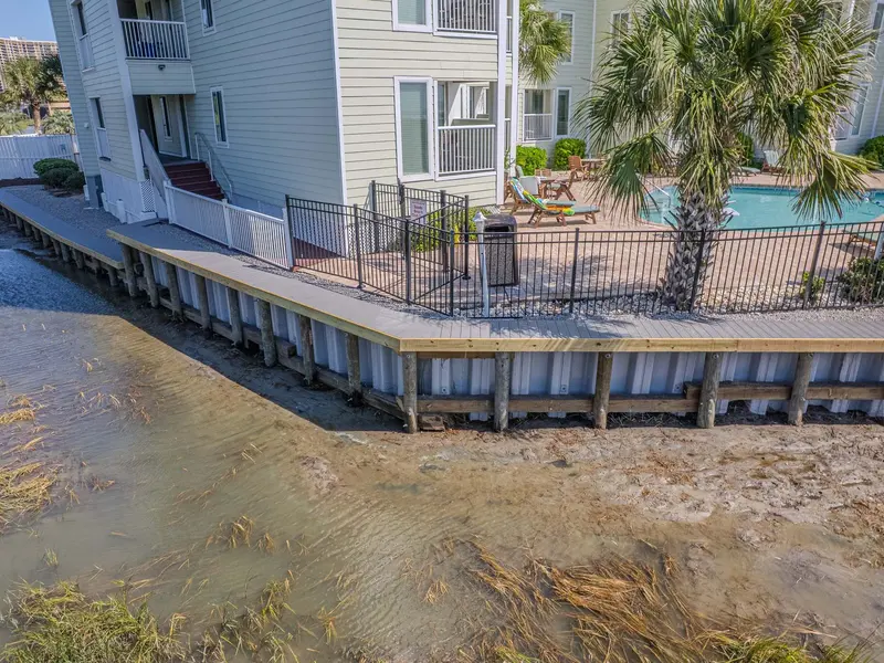 Finished vinyl bulkhead with timber posts and cap beside the pool at Sands Beach Club HOA