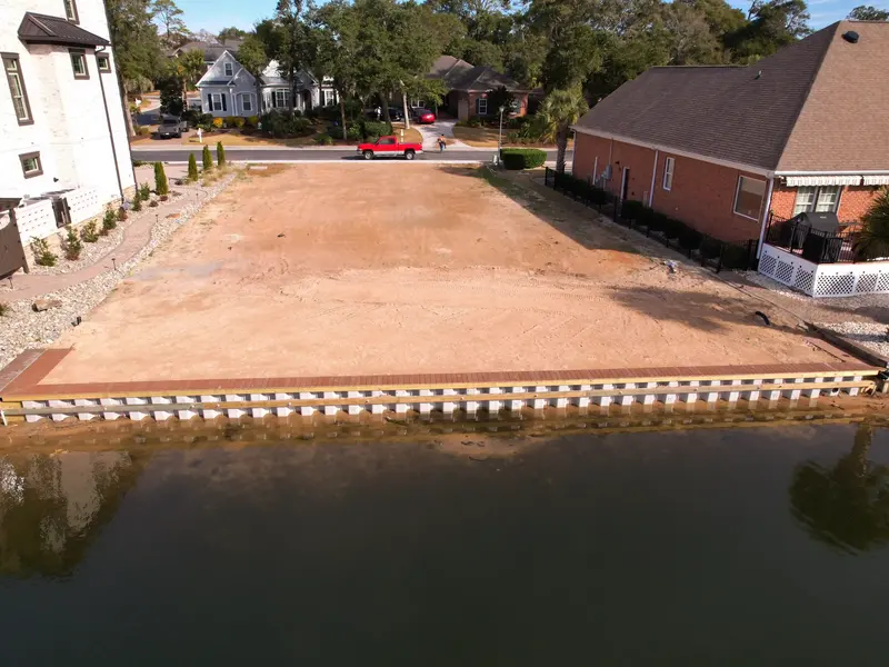 Completed vinyl bulkhead and timber cap along a lakefront lot at Seaside Plantation in North Myrtle Beach