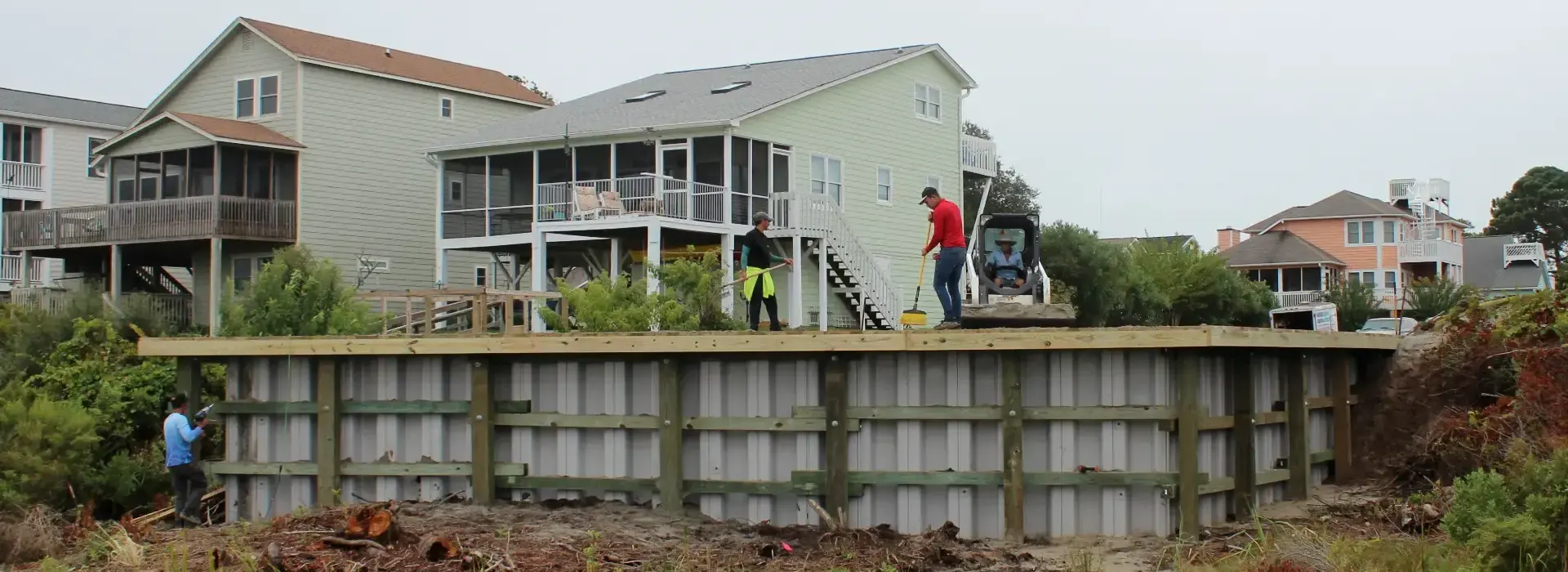 Crew working along a residential seawall during shoreline construction